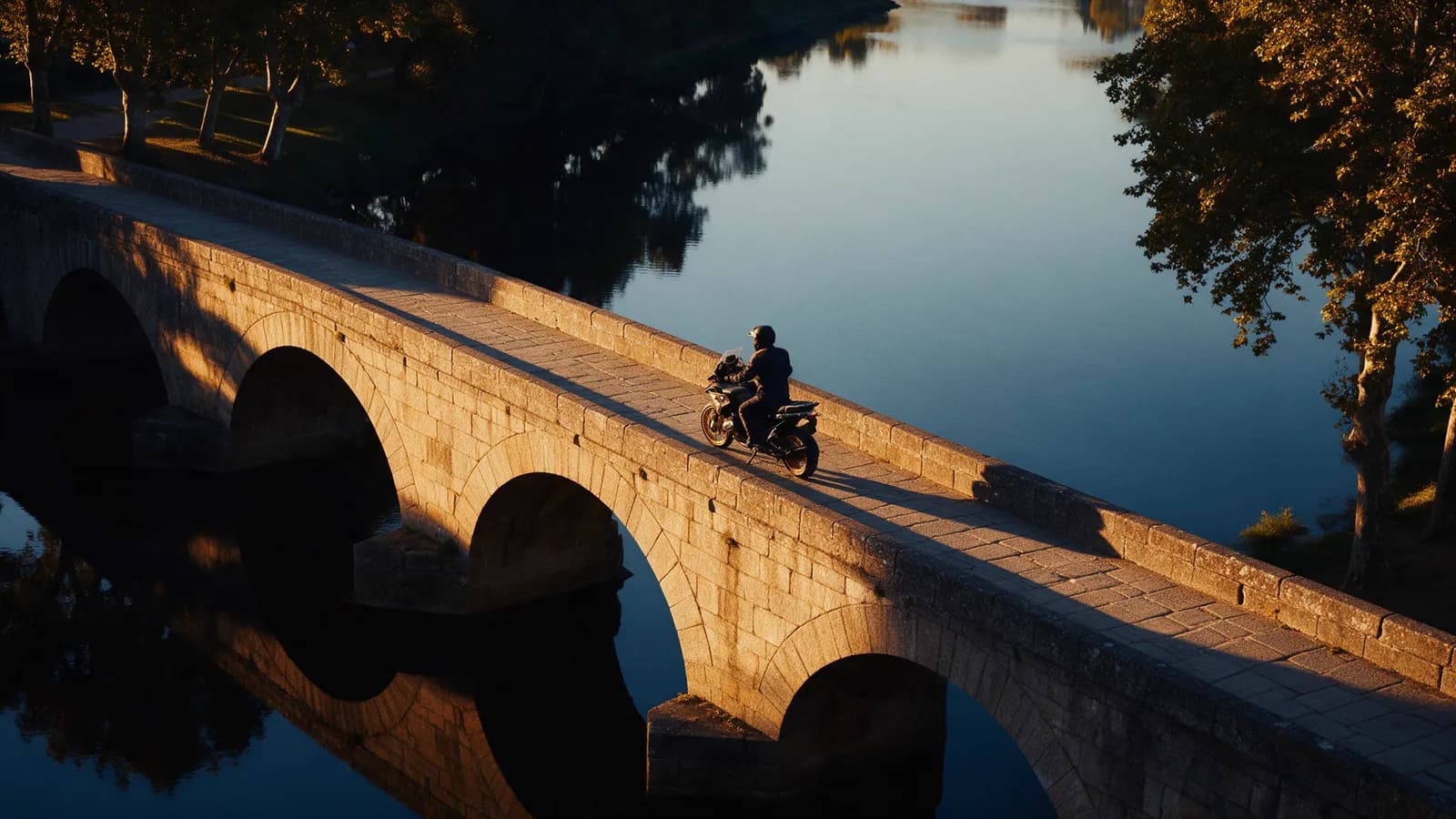 Piloto atravessando de moto a ponte medieval de Ponte de Lima